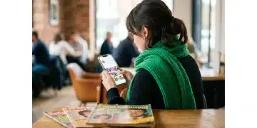 A woman engaged with a smartphone displaying a celebrity's social media feed, with old magazines in the foreground, symbolizing the shift from traditional to digital influence in celebrity culture.