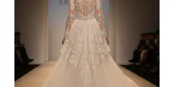 Vestido de novia de alta costura 2026, con encaje y silueta fluida, en pasarela elegante.