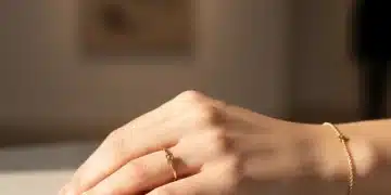 Mujer luciendo anillo y pulsera minimalistas de oro, joyería española elegante.